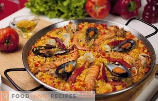 Paella with seafood - plov in Spanish style. Cooking paella with seafood and beans, corn, peas, fish
